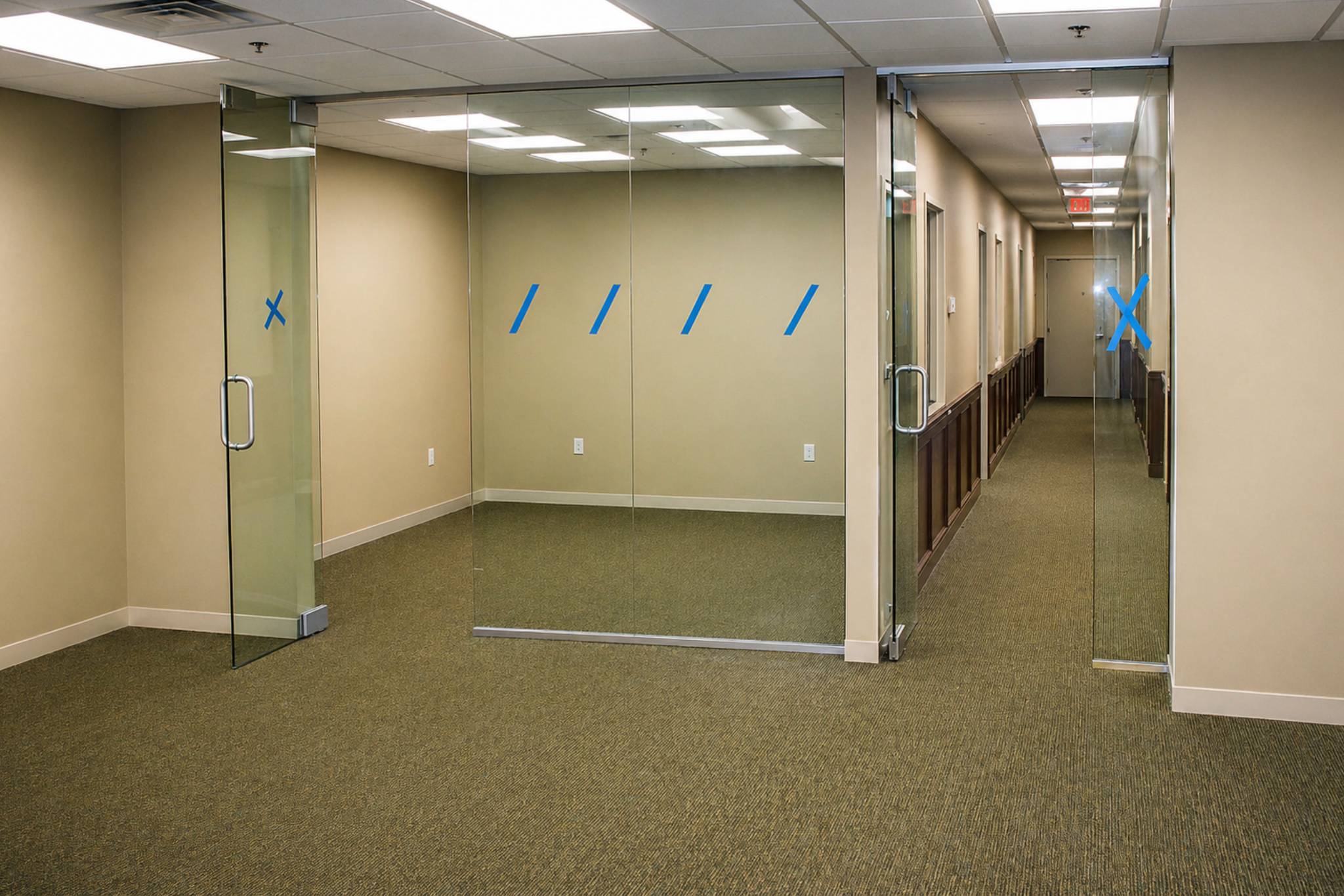 Modern office corridor with glass partitions.